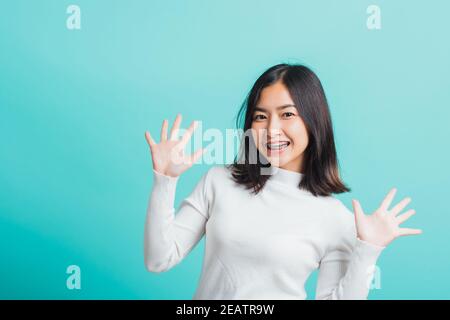 donna allegro trucco sorridente mostrando mani aperte Foto Stock