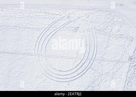 Paesaggio invernale innevato nella foresta bavarese con tracce di pneumatici per auto impronte di slitte in neve profonda, Germania Foto Stock