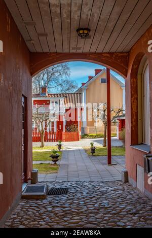Case di legno lungo una strada stretta a Nora, Svezia Foto Stock