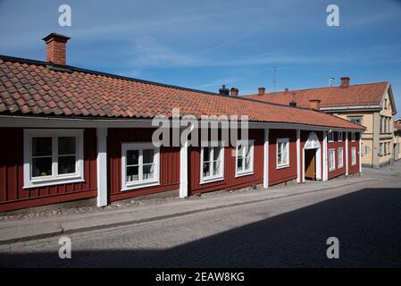 Case di legno lungo una strada stretta a Nora, Svezia Foto Stock