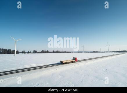 Il carrello si sposta su un'autostrada invernale con un'antenna di sfondo blu vista sul drone Foto Stock