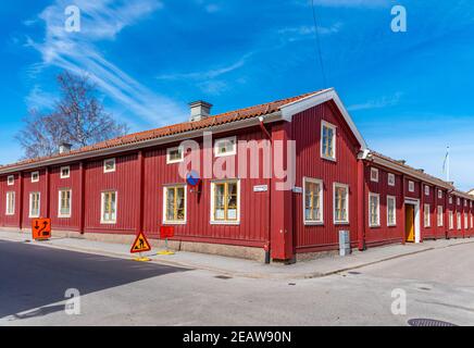 Case di legno lungo una strada stretta a Nora, Svezia Foto Stock