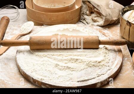 farina di grano bianco e spilla di legno a bordo, ingredienti da forno Foto Stock