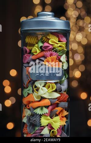 Pasta di diversi colori in un bicchiere Foto Stock