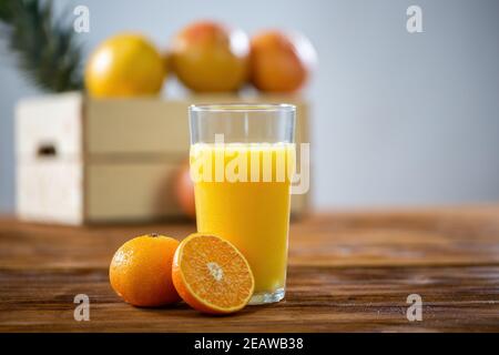 Bicchiere di succo d'arancia sgombato su un tavolo di legno Foto Stock