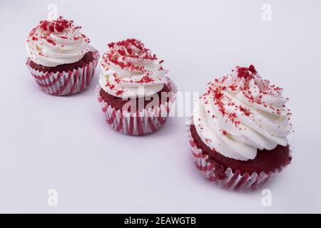 Primo piano di gustosi cupcake di velluto rosso su sfondo bianco Foto Stock
