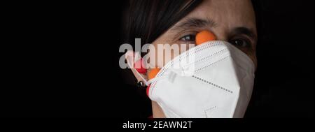 vista panoramica di una donna che indossa una maschera ffp2 bianca Protezione da Covid19 con la gomma nell'orecchio incrociata e con i virus colorati che escono dovuto Foto Stock