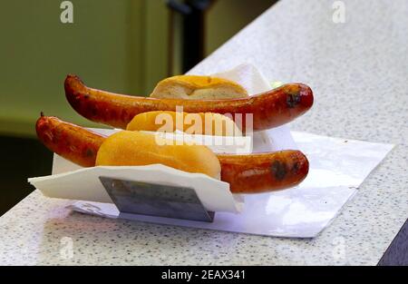 Primo piano due salsicce di Bratwurst tedesche grigliate e servite con un pezzo Di pane visto sul mercato di Natale di Amburgo Foto Stock