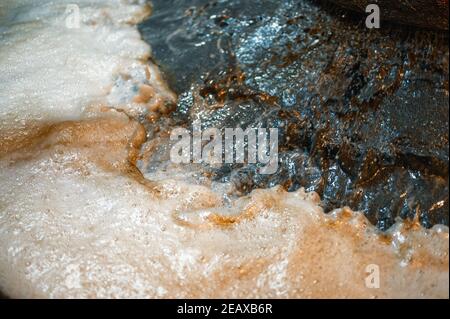 Processo di flottazione industriale. Riprese ravvicinate. La corrente di liquido e minerale viene separata in frazioni liquide e schiume Foto Stock