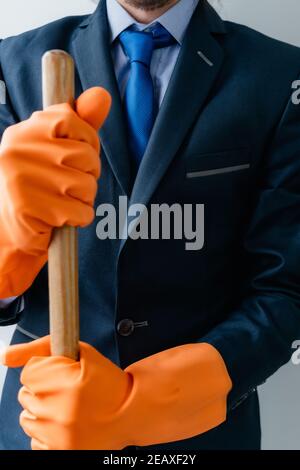 uomo d'affari in tuta blu monocromatica che tiene forniture di pulizia. giorno del lavoro Foto Stock