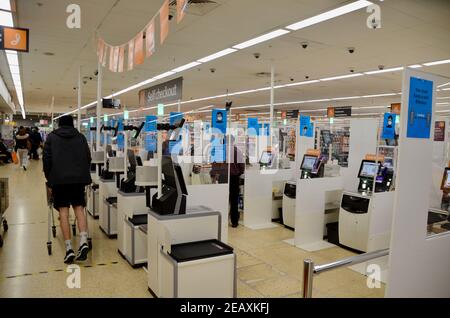 Area di check-out socialmente distante a Sainsbury's haringey london con acquirenti e personale Foto Stock