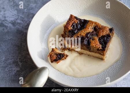 Torta di prugna secca e noce con crema alla vaniglia Foto Stock