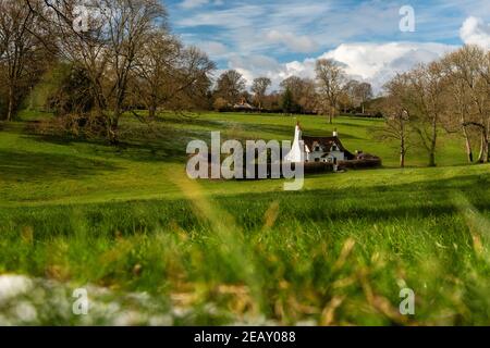 Soleggiato paesaggio invernale di Chiltern Hills con un piccolo cottage tra le colline, Inghilterra Foto Stock
