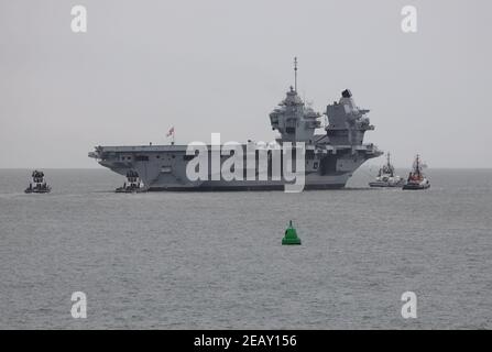 Tugs accompagnano la Royal Navy Queen Elizabeth classe portaerei HMS PRINCIPE DI GALLES nel solente Foto Stock