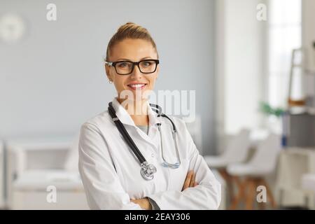 Ritratto di felice giovane medico in camice bianco di laboratorio e. occhiali sorridenti alla macchina fotografica Foto Stock
