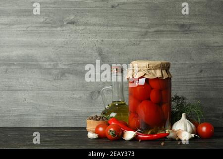 Pomodori e ingredienti sottaceto su sfondo grigio Foto Stock