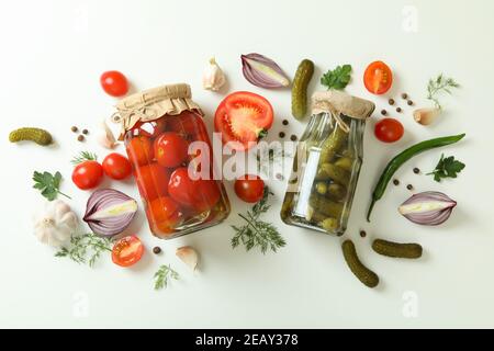 Vasetti di cetrioli e pomodori in scatola e ingredienti su sfondo bianco Foto Stock