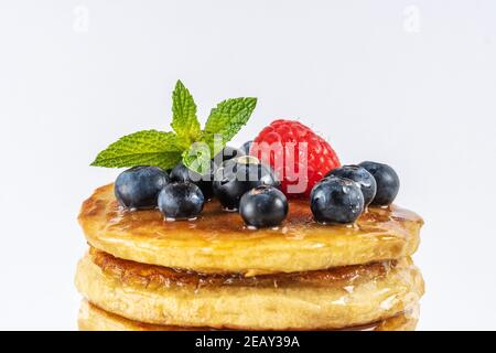 Deliziosi pancake con frutti di bosco freschi su sfondo bianco. Concetto di cibo. Primo piano. Foto Stock
