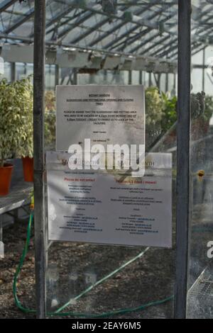 Serre Botaniche con segni bilingue avvertimento di Covid-19 pandemia in Gallese e inglese presso il dipartimento di ricerca scientifica del Campus di Abery Foto Stock