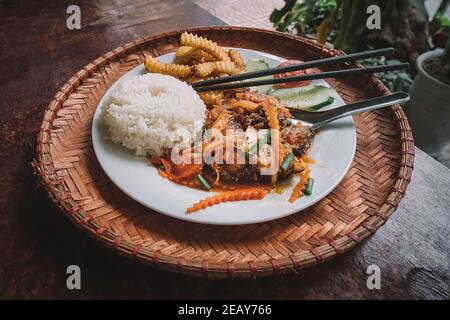 Riso al curry giapponese con carne di maiale, carote e cipolle a fette - stile asiatico. Riso bollito e curry di carne, cucina orientale Foto Stock