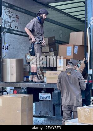 FRESNO, STATI UNITI - Feb 10, 2021: Una foto dei dipendenti di consegna della posta con le scatole sul retro del camion Foto Stock