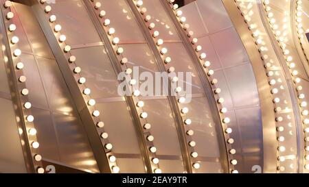 Le vecchie lampade elettriche che funzionano lampeggiano e si illuminano di notte. Primo piano astratto della decorazione del casinò retrò scintillante a Las Vegas, Stati Uniti. Luce di colore Foto Stock