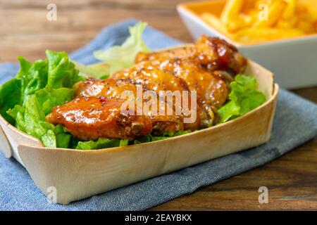 ali di pollo al chutney di mango con patatine fritte e insalata Foto Stock