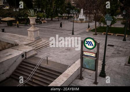 Athen, Grecia. 11 Feb 2021. Una donna attraversa la piazza vuota di Syntagma. Da giovedì mattina la zona di Atene è stata nuovamente sottoposta ad un duro blocco per contenere la pandemia di Corona, il cui rispetto viene imposto dalla polizia con numerosi ostacoli stradali. Credit: Angelos Tzortzinis/DPA/Alamy Live News Foto Stock