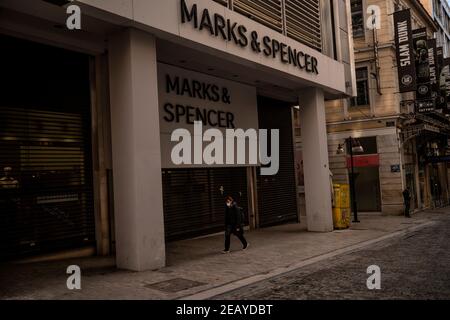 Athen, Grecia. 11 Feb 2021. Una donna passa accanto a negozi chiusi nella principale strada dello shopping Ermou. Da giovedì mattina, la zona di Atene è stata nuovamente sottoposta a un duro blocco per contenere la pandemia di Corona, il cui rispetto è stato imposto dalla polizia con numerosi blocchi stradali. Credit: Angelos Tzortzinis/DPA/Alamy Live News Foto Stock