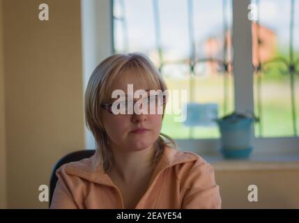 Bel ritratto di donna caucasica matura seduta accanto alla finestra con sorriso caldo e meditare Foto Stock