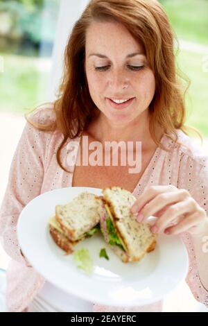 Donna di mangiare un panino Foto Stock