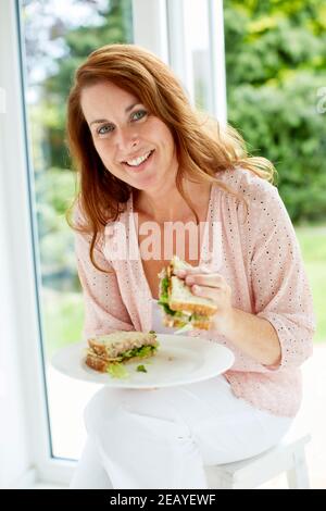 Donna di mangiare un panino Foto Stock