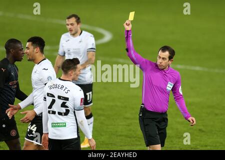 L'arbitro Peter Bankes mostra una carta gialla e libri ben Cabango di Swansea città (l) dopo un fallo su Ilkay Gundogan di Manchester City . Emirates fa Cup, 5° round match, Swansea City contro Manchester City al Liberty Stadium di Swansea, Galles del Sud, mercoledì 10 febbraio 2021. Questa immagine può essere utilizzata solo per scopi editoriali. Solo per uso editoriale, è richiesta una licenza per uso commerciale. Nessun utilizzo nelle scommesse, nei giochi o nelle pubblicazioni di un singolo club/campionato/giocatore. pic di Andrew Orchard/Andrew Orchard sports photography/Alamy Live news Foto Stock