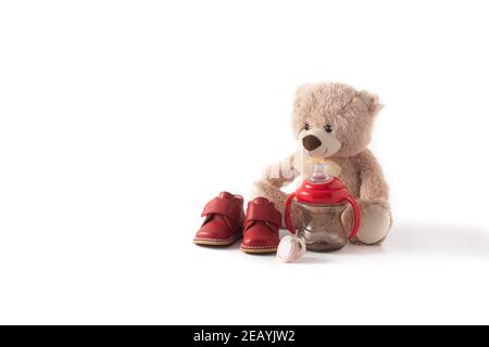 Ropper, scarpe, biberon, succhietto e orsacchiotto isolati su sfondo bianco Foto Stock