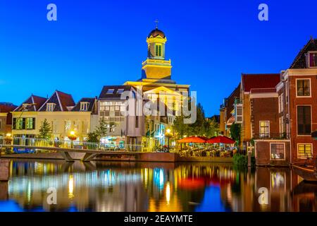 LEIDEN, PAESI BASSI, 8 AGOSTO 2018: Vista notturna di Hartebrugkerk dietro un canale a Leiden, Paesi Bassi Foto Stock