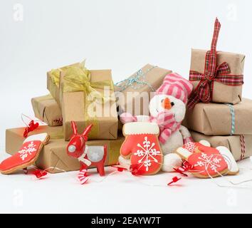 una pila di regali avvolti, biscotti natalizi su sfondo bianco, primo piano Foto Stock