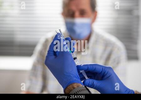 l'uomo anziano riceve il vaccino del coronavirus Foto Stock