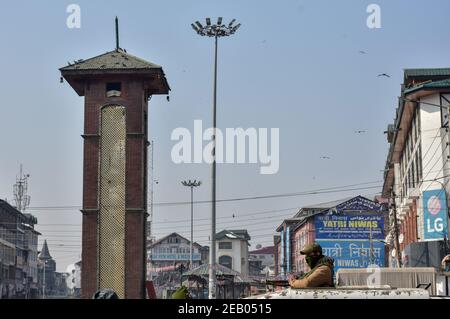 Srinagar, India. 11 Feb 2021. Un poliziotto si alza in guardia sulla parte superiore di un veicolo di polizia in un mercato chiuso durante shutdown.A arresto è stato osservato in Kashmir per celebrare il 37 ° anniversario di morte di Jammu e Kashmir Liberation Front (JKLF) fondatore Mohammad Maqbool Bhat, Che è stato impiccato nella prigione Tihar di Nuova Delhi in questo giorno nel 1984. Credit: SOPA Images Limited/Alamy Live News Foto Stock