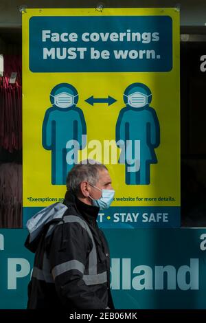 Watford, Regno Unito. 11 febbraio 2021. Un cartello che richiede l'uso di un facemask nella finestra di un negozio nel centro di Watford, mentre la pandemia del coronavirus continua. Il governo britannico sta tentando di raggiungere il suo obiettivo di 15 milioni di vaccini somministrati entro il 15 febbraio, con 13,5 milioni di vaccini somministrati finora. Credit: Stephen Chung / Alamy Live News Foto Stock