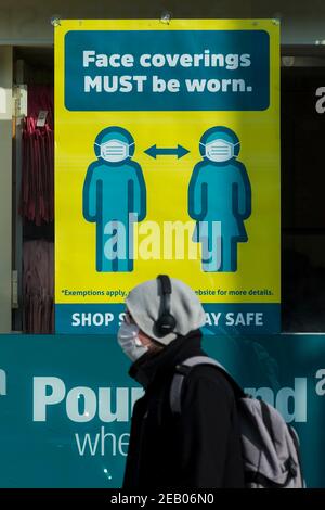 Watford, Regno Unito. 11 febbraio 2021. Un cartello che richiede l'uso di un facemask nella finestra di un negozio nel centro di Watford, mentre la pandemia del coronavirus continua. Il governo britannico sta tentando di raggiungere il suo obiettivo di 15 milioni di vaccini somministrati entro il 15 febbraio, con 13,5 milioni di vaccini somministrati finora. Credit: Stephen Chung / Alamy Live News Foto Stock