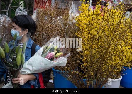 Hong Kong, Cina. 11 Feb 2021. Un acquirente che indossa una maschera facciale acquista bouquet in un mercato dei fiori nel quartiere di Price Edward prima dell'inizio del Capodanno lunare. Credit: SOPA Images Limited/Alamy Live News Foto Stock