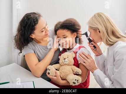 Pediatra che esamina un piccolo paziente con un otoscopio, controllo uditivo per il bambino Foto Stock