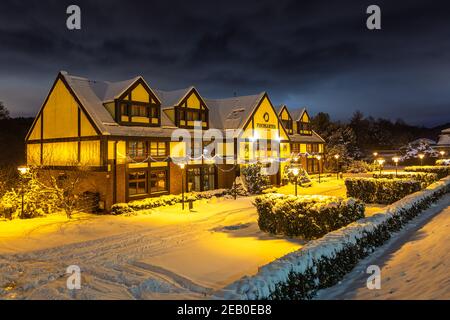 Gdansk, Oliwa, Polonia - 16 gennaio 2021 - Vista della città vecchia illuminata e innevata di Oliwa. Fishgarten Hotel. Foto Stock