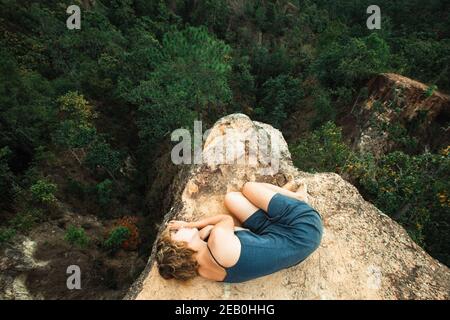 Giovane ragazza sdraiata in cima alla roccia nel canyon. Foto Stock