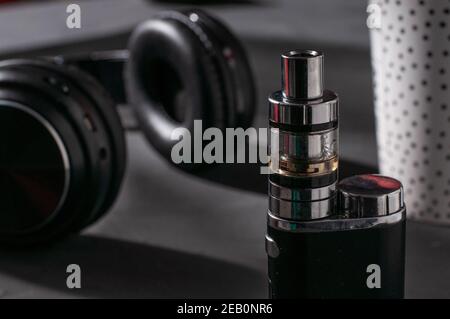 Pod vape ricaricabile con cuffie sullo sfondo Foto Stock