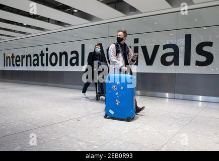 Londra, Regno Unito. 11 Feb 2021. Arrivi internazionali al Terminal 5 di Heathrow. Le persone che arrivano in Inghilterra dai paesi 'lista rossa', compresi i residenti nel Regno Unito, devono isolare per 10 giorni in hotel, al costo di £1,750 dal 15 febbraio. Il Segretario della Sanità ha fatto l'annuncio nella Camera dei Comuni il 10 febbraio. Credit: Mark Thomas/Alamy Live News Foto Stock