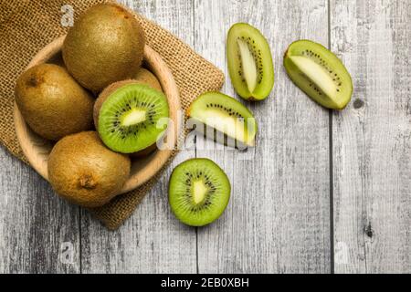 vista dall'alto della frutta kiwi sulla ciotola con le fette di legno tabella Foto Stock