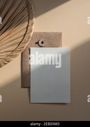 Scheda di carta bianca vuota non rivestita isolata su sfondo beige in stile boho Foto Stock