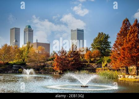 11-16 2020 - Tulsa USA - Vista da Central Park Del centro di Tulsa Oklahoma in un luminoso giorno d'autunno con colorato fogliame e lago e fontane in uscita Foto Stock