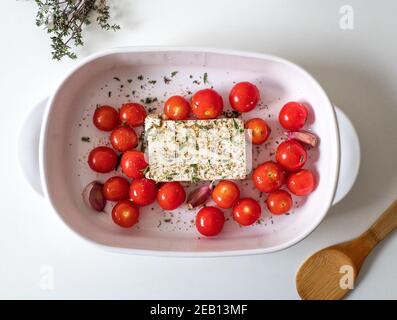 Feta virale cuocere la ricetta della pasta con pomodori, aglio ed erbe in un piatto di casseruola Foto Stock